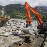 Cinq pelleteuses travaillent à nettoyer et à sécuriser le torrent du Fregnoley afin de recréer un pont fusible donnant accès à Lourtier et au haut Val de Bagnes. KEYSTONE/VALENTIN FLAURAUD